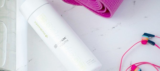 bottle of ageLOC Youth by Pharmanex with exercise gear - Nu Skin